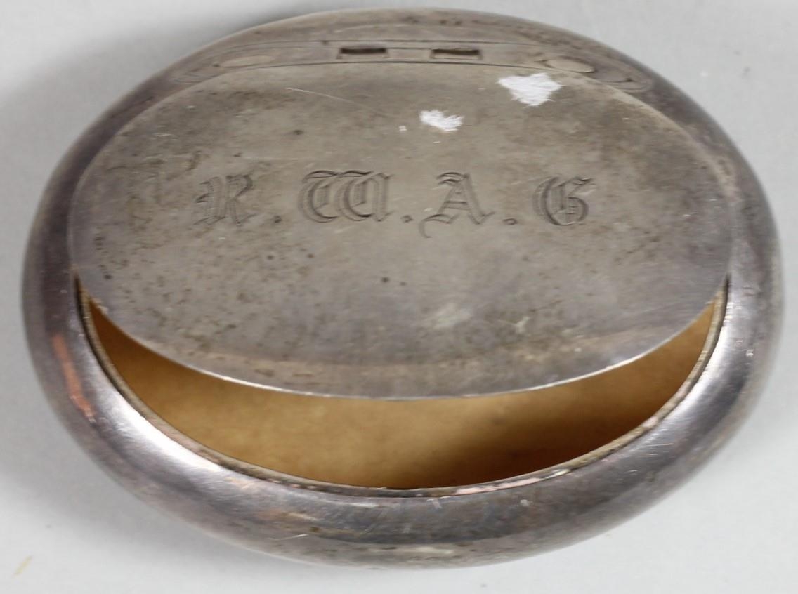 A silver oval tobacco box, Birmingham 1902, of squeeze opening form, 8 x 6 cm, 2 oz.