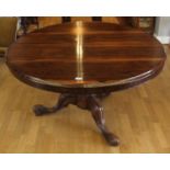 A Victorian rosewood tilt-top dining table raised on a octagonal baluster pedestal with carved