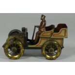 An early 20th century tin plate model of a car & driver.