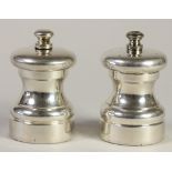 A silver salt grinder, London 1889, 7cm, and a matching electroplated example (2).