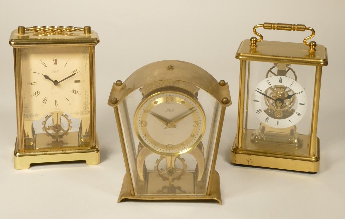 A Schatz 8 day, brass carriage time piece with visible escapement, together with another similar