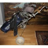 A selection of golf clubs/irons, makers to include Wilson, Gallery and Donnay, compete with golf bag