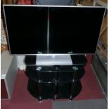 A silver 42" Panasonic HD 1080p LCD TV (TXL42E6B), together with a 3 tier, black T.V stand (No