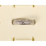 A platinum wedding band with cast floral decoration, stamped PLAT, 8.3 gm, P