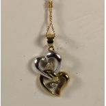 A 9ct two colour gold double heart pendant, set with diamonds, chain, 2.2gm