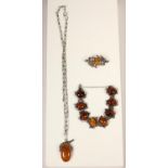 A silver and amber 8 panel bracelet, a silver and amber pendant and a similar brooch