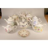 A collection of eight commemorative ceramic teapots, primarily from the 1980's, celebrating the
