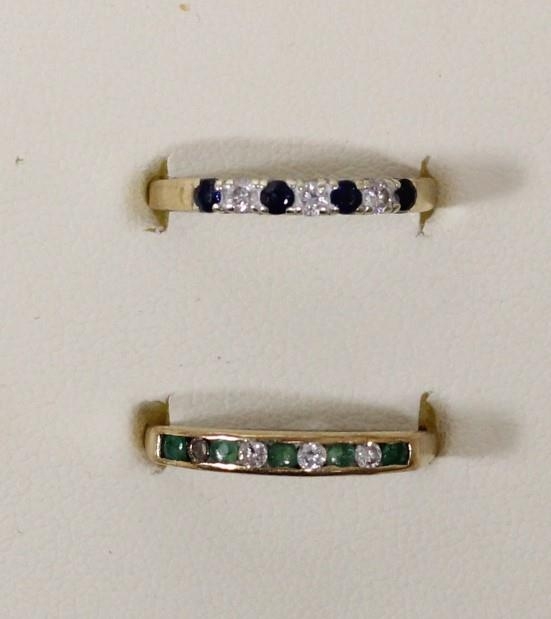 A 9ct gold emerald and diamond channel set ring, one diamond vacant, P and a sapphire and diamond