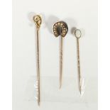 A Victorian gold mounted black onyx and half pearl horseshoe stickpin and two other stickpins, 4.3gm