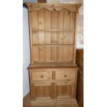 A traditional pine dresser, the base having two drawers between two cupboards with turned wooden