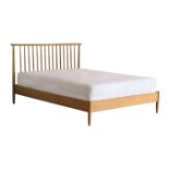 An Ercol Teramo king size bed frame, with turned and tapered spindles, handcrafted from solid pale