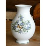 A Royal Worcester flower vase of bulbous for, decorated with herbs. 26cm tall.