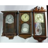 A collection of clocks to include, a William Dale quartz wall clock, together with other wooden wall