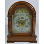 An Ansonia Clock Company, New York walnut mantel clock, the arched dial with silvered chapter rim,