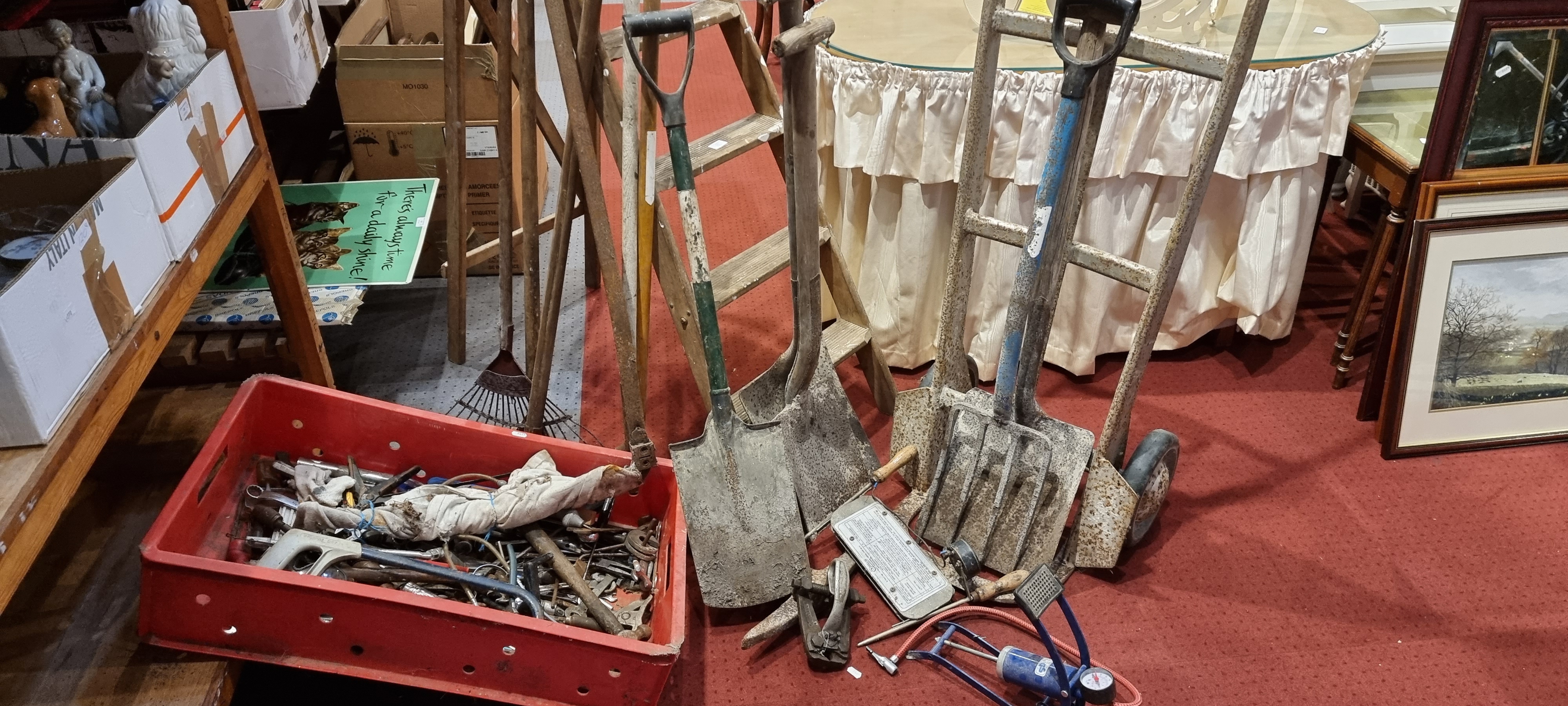 A selection of hand tools, a five step wooden ladder, sack barrow, foot pump, old garden tools.