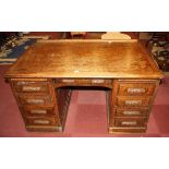An oak pedestal knee hole desk (minus the roll top) with central drawer, flanked by four drawers