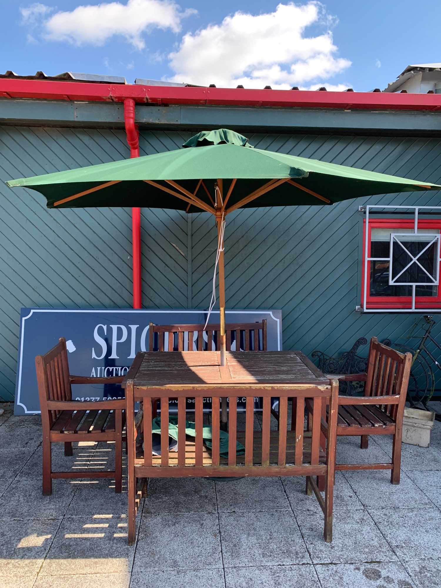 A wooden garden dining set, consisting of a table, two matching wood benches, two matching wooden