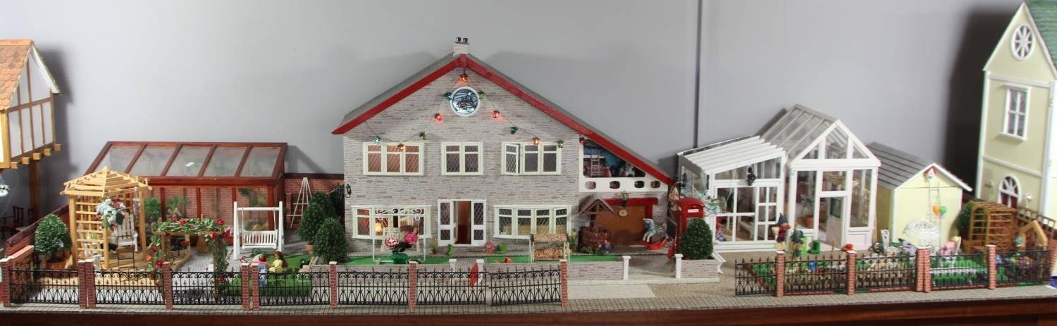 A large hand built dolls house diorama, composed of a two story chalet type house with integral