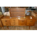 A Mid Century G-Plan sideboard, featuring solid teak & brass drop handles, bank of three graduated