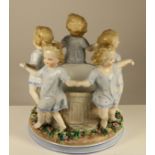 An Ernst Bohne and Sohne porcelain figure of girls skipping around a well, stamped to base, 18 x