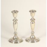 A pair of silver candlesticks, stamped STERLING, with baluster stems and gadrooned border, 21cm,