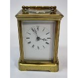 A brass striking carriage clock, the white enamel dial with Roman numerals, the movement striking on