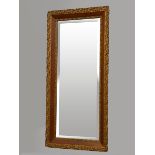 An Edwardian carved giltwood and mahogany rectangular wall mirror, with beveled edge glass,