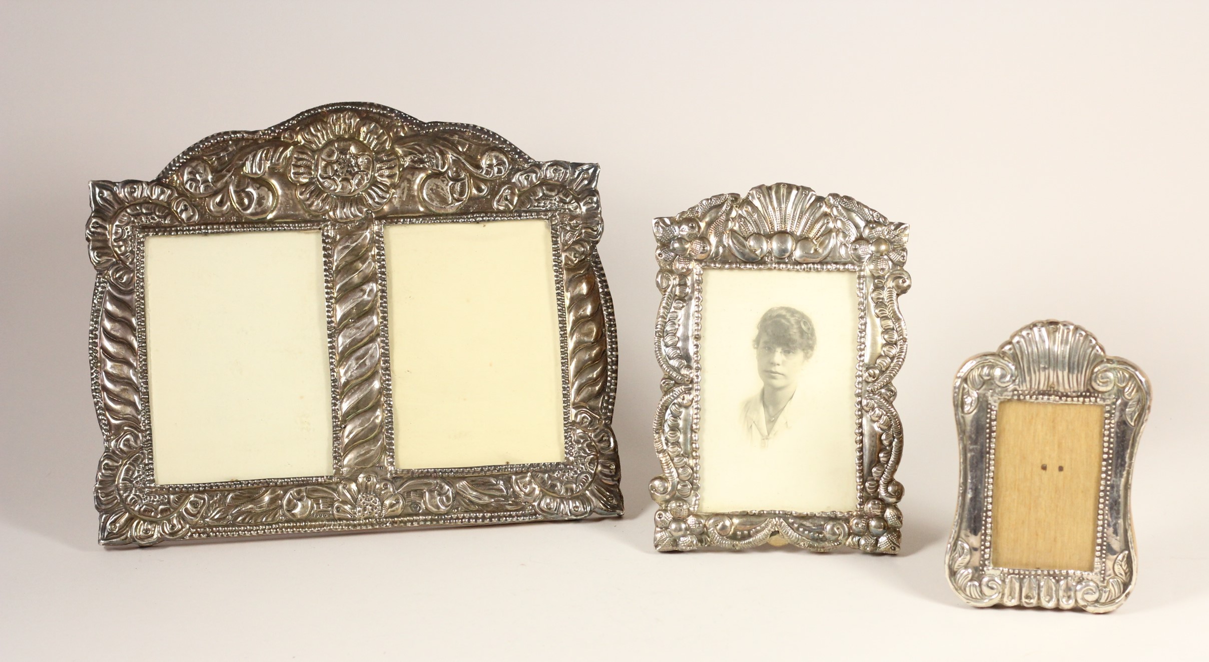 A silver mounted double photograph frame, stamped 925, with embossed decoration, 22 x 27cm and two