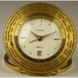 An Asprey Luxor 8 day world time desk alarm and date brass clock, with 66 countries to the