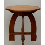 An Arts & Crafts oak side table, octagonal shaped top with lower cross member, raised on four curved