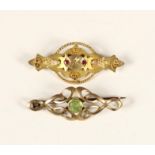 An Art Nouveau rose gold and peridot scroll brooch, unmarked and a Victorian 9ct gold red paste