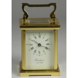 A brass carriage clock, the enamel dial signed Woodford, Est 1860, Roman numerals, the movement