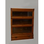 An early 20th century inlaid mahogany Globe Wernicke three section library bookcase, each with an '