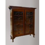 An English Art Nouveau mahogany display cabinet, with original leaded coloured glass doors, interior