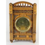 An Arts and Crafts mantle clock, brass dial with Roman numerals, the case with carved decoration,