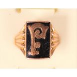A 9ct rose gold and onyx signet ring, letter F, reeded shoulders,