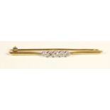 An Edwardian 18ct gold and diamond set bar brooch, stamped 18ct, milligrain collet set with