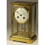 A French four glass brass mantle clock, the white enamel dial with Arabic numerals, the movement