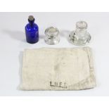 A glass inkwell stamped LMS, a small metal paperweight inscribed LNER, a small blue bottle stamped