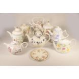 A collection of eight commemorative ceramic teapots, primarily from the 1980's, celebrating the