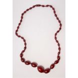 A cherry amber graduated necklace, 30 x 20 mm down to 12 x 7 mm, twist clasp, length 78cm, 54 gm