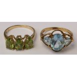 A 9ct gold three stone peridot ring, O and a 9ct gold pale blue three stone ring, O, 5.7gm