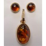 A Polish 14ct gold and amber pendant and a matching pair of ear studs, both with certificates.