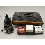 An Atari 2600 "woody" console, together with two joysticks, power cable and seven games, including