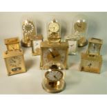 A brass cased kundo anniversary mantle clock together with a collection of barometers and carriage