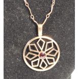 An Edwardian 9ct rose gold and garnet geometric pendant, 9 tab, 23mm diameter, 4.5gm