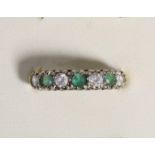 An unmarked gold emerald and white paste seven stone ring, P, 2.9gm