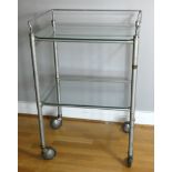 An early 20th century two tier medical trolley with removable glass shelves galleried, chrome and