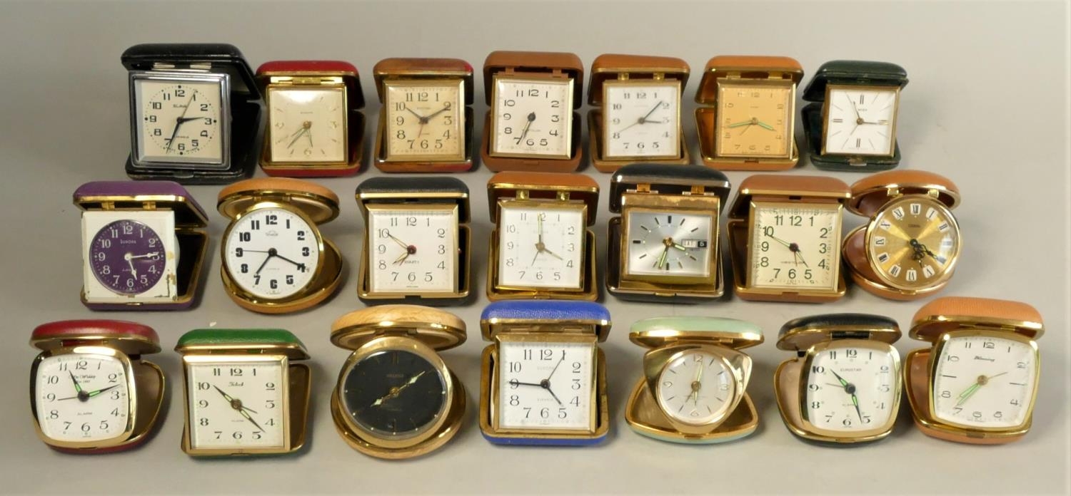 A collection of travel alarm clocks together with a selection of mid Century mantle clocks &