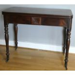 A Georgian mahogany fold over side table, on turned and tapered legs with brass casters, 77cm high